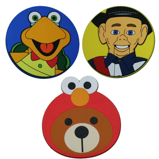 Three custom PVC coasters featuring colourful cartoon characters: a green frog, a cowboy, and a bear with a red outline.