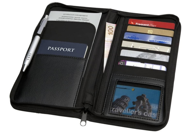A black Meridian Travel Wallet containing a passport, cards, cash, and a pen, with a zippered closure.