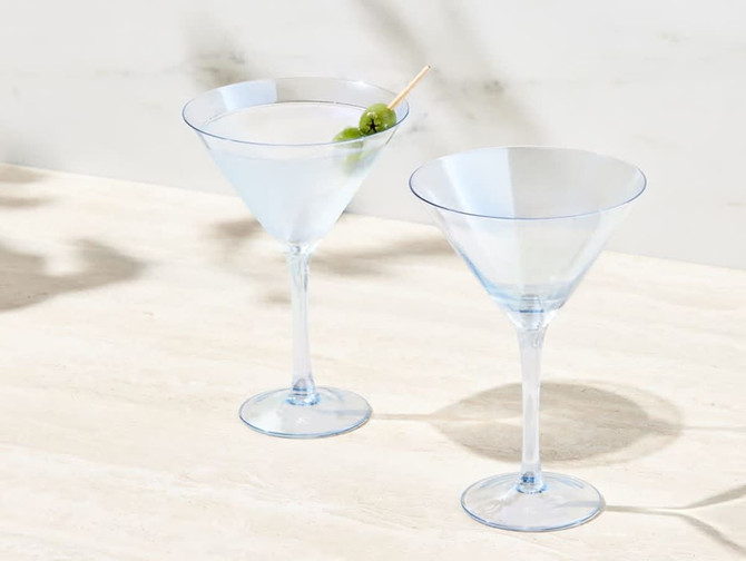 A set of two elegant clear martini glasses with a light blue tint, featuring one with an olive garnish.