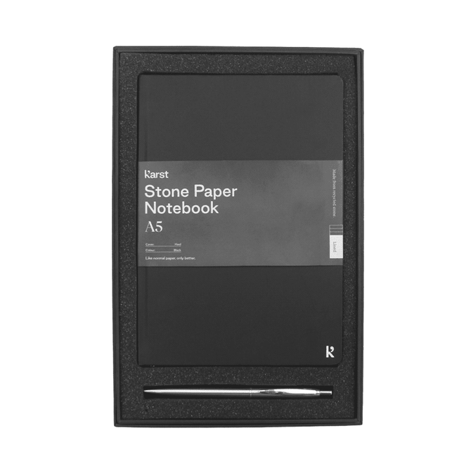A black A5 stone paper hardcover notebook and a silver recycled stainless steel pen in a gift box.