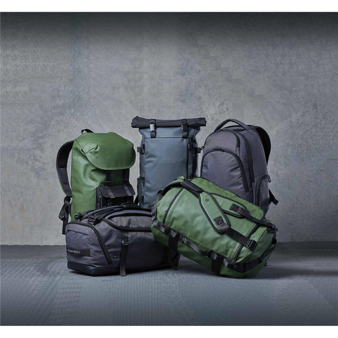 Five backpacks in various shades of green and grey, featuring different styles and designs, with logos visible.