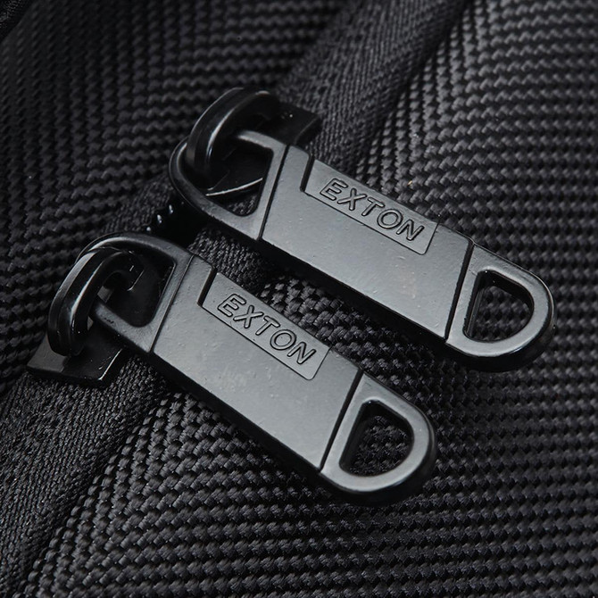 Close-up of black zippers with a branding logo on a textured fabric, part of the Exton Laptop Backpack.