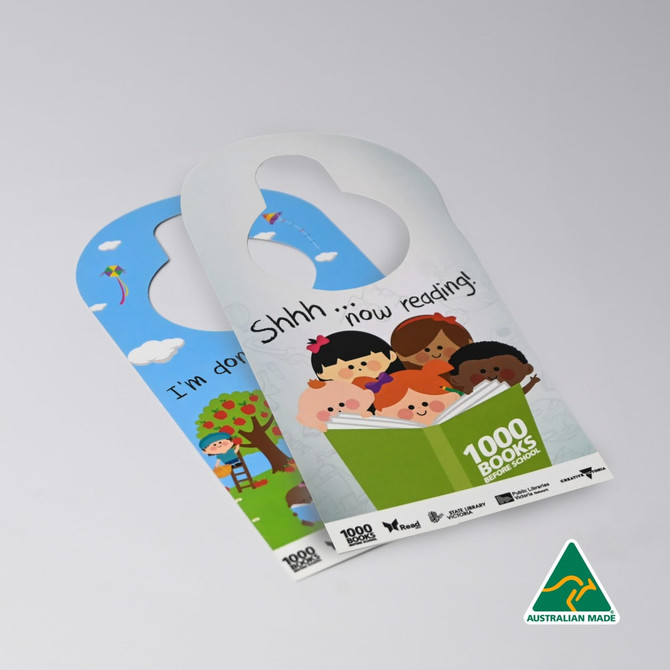 A double-sided door hanger featuring colourful illustrations of children reading and playful scenes, with a logo.