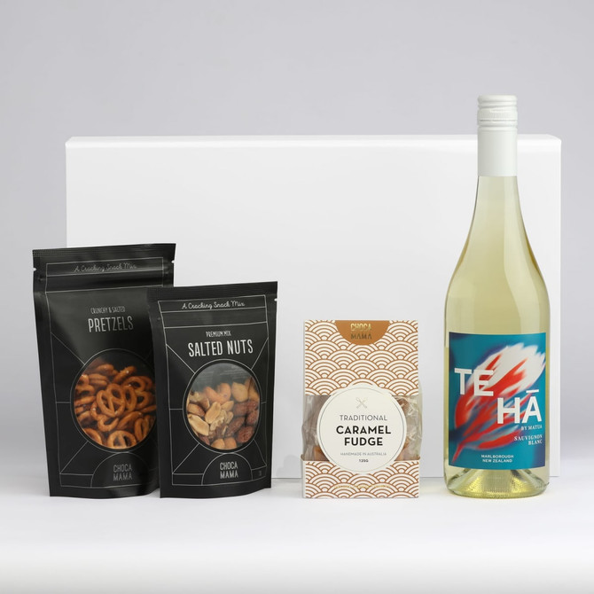 A drink bottle of white wine accompanied by salt pretzels, salted nuts, and caramel fudge, all in branded packaging.