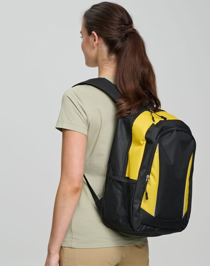 A black and yellow backpack is worn on the back of a person facing away from the camera. The backpack has a logo.