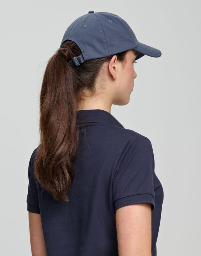 A navy cotton twill unstructured cap featuring a rear adjustment strap and worn by a person with long hair.