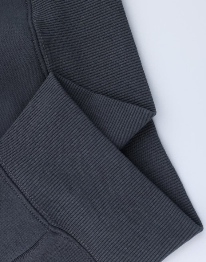 A close-up of grey oversized fleece hoodie cuffs with a textured ribbed finish and visible stitching.