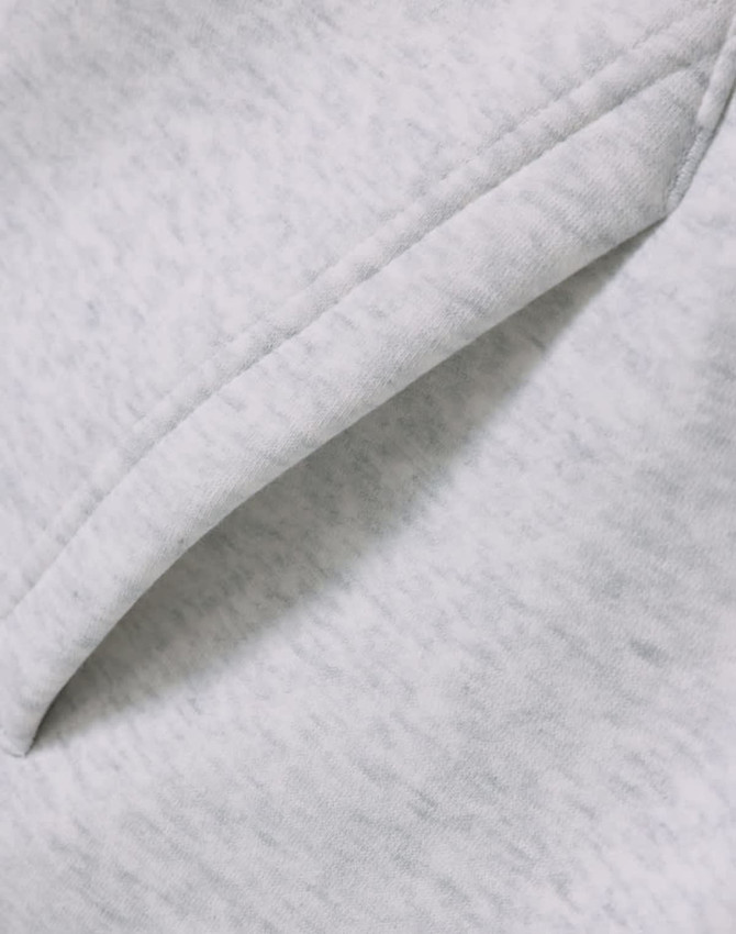 A close-up of a soft, grey fleece fabric featuring a folded edge, showcasing the texture.