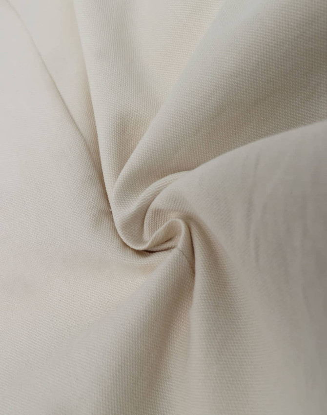 A textured light beige fabric, featuring a smooth and soft cotton blend suitable for shirt design.