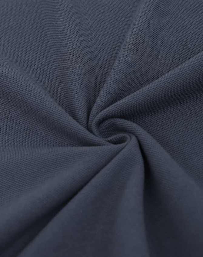 A close-up of navy cotton/poly pique fabric, showcasing the texture and drape of the material.
