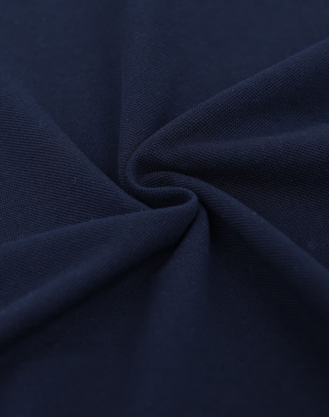 A fabric swatch in navy blue, showcasing a smooth, textured cotton/poly pique weave.