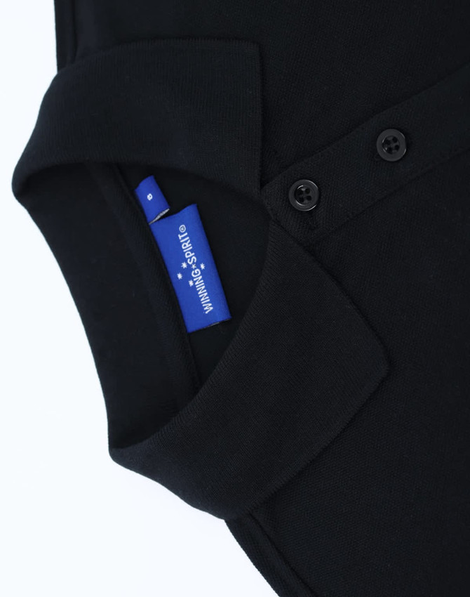 A black ladies' classic cotton/poly pique short-sleeve polo featuring a collar and buttons, with a label visible.