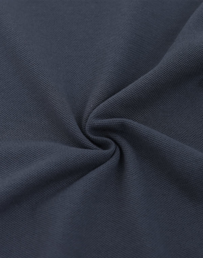 A close-up of dark navy fabric featuring a textured pique weave, highlighting its softness and quality.