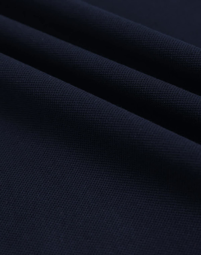A close-up of navy ultrafine cotton pique fabric, showcasing its texture and weave.