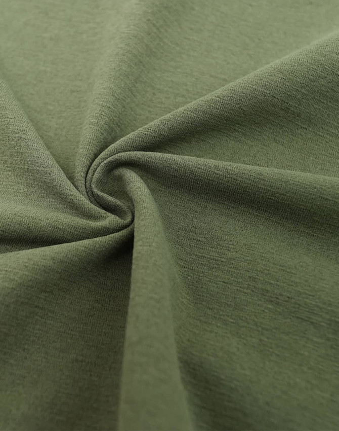 A close-up of a green fabric, showcasing its texture and softness, with a circular twist pattern.