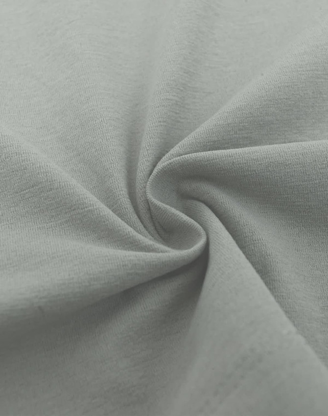 A close-up of light grey fabric showcasing a smooth, high-performance texture with a slight swirl pattern.