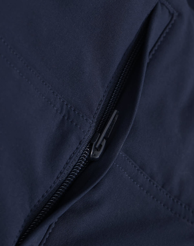 A close-up of navy water-repellent flexi work pants featuring a zippered pocket and detailed stitching.