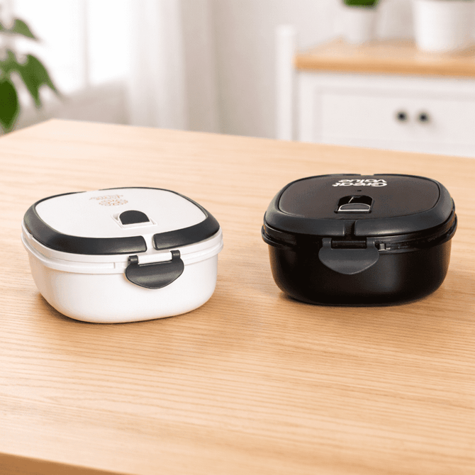 A lunch box set featuring a black and a white container, both with secure lids and separate compartments.