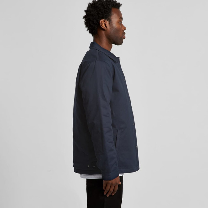 A navy work jacket displayed on a model from the side, featuring a logo on the fabric.