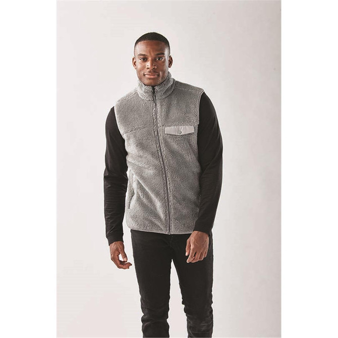 A grey Sherpa fleece vest with a zip front and a chest pocket, worn over a black long-sleeve shirt.