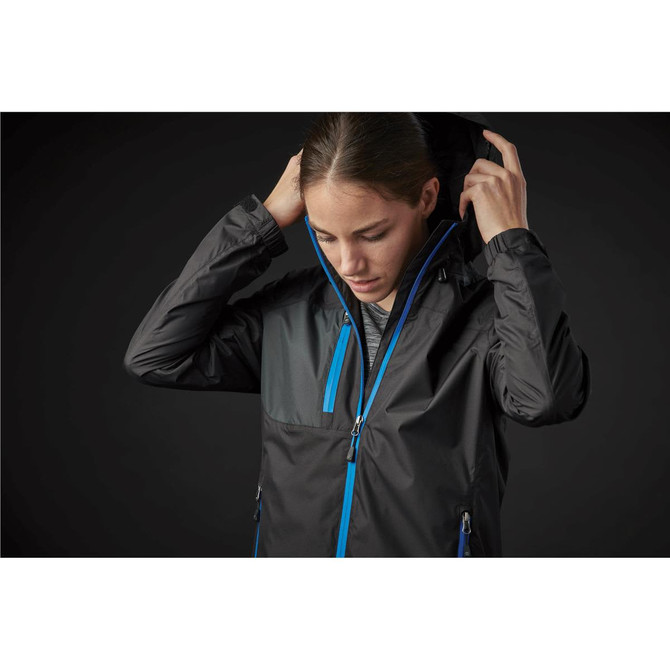 A woman adjusts the hood of a black rain jacket with blue accents. The jacket features a zip-up front and pockets.