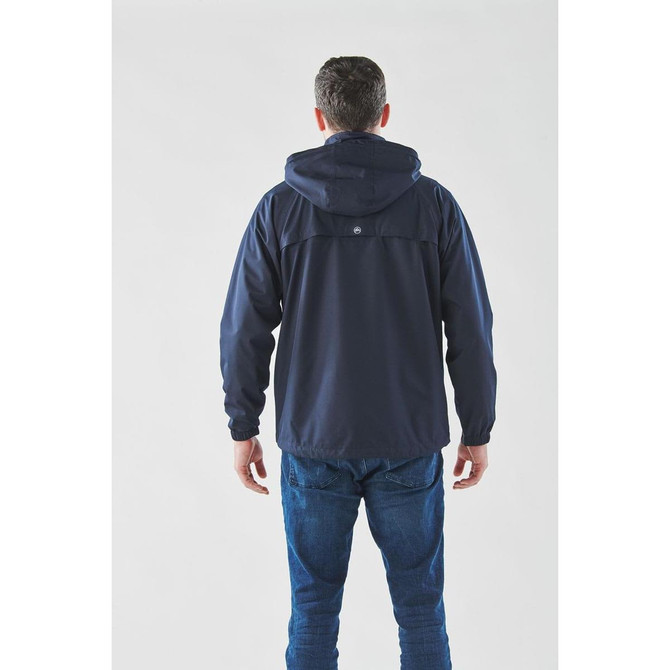 A man wearing a navy lightweight rain jacket with a hood, showing the back view. The jacket features a logo.