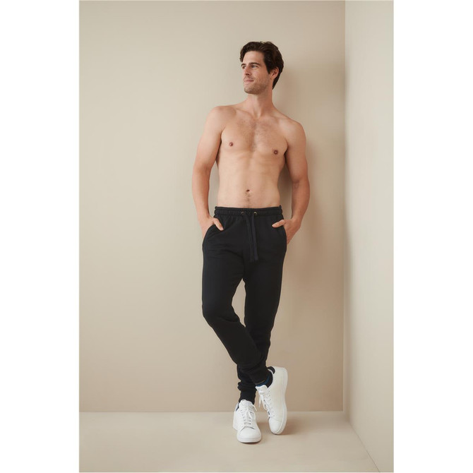 Recycled unisex sweatpants in black, featuring side pockets and an elastic waistband, worn by a model.