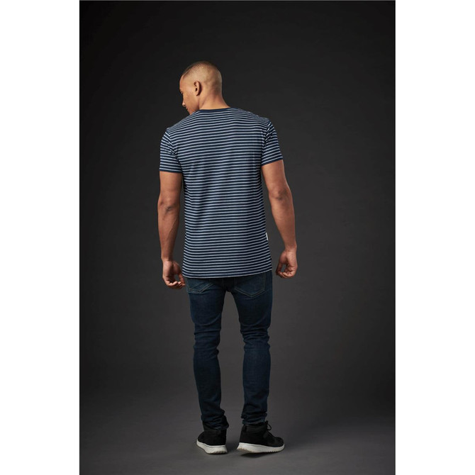 A men's crew neck tee featuring a blue and white striped design, paired with dark jeans. The model is viewed from the back.