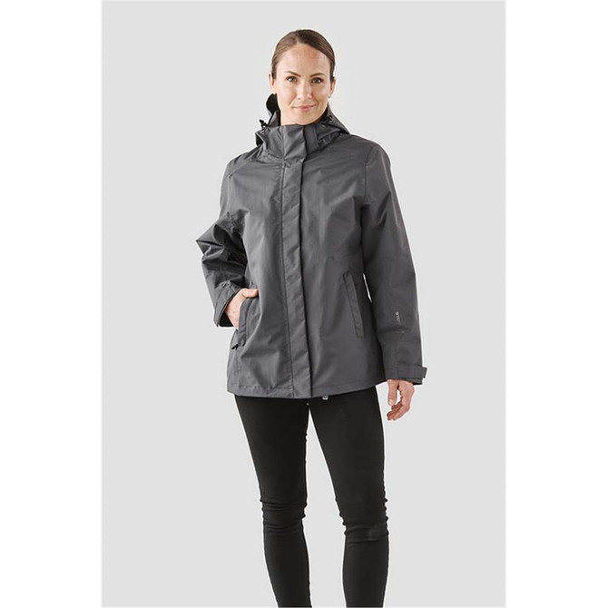 A woman wearing a grey Women's Magellan System Jacket with a hood, featuring a logo and black pants.