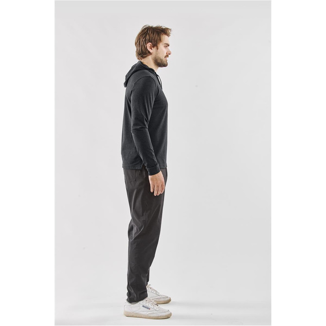 A side view of a man wearing a black hooded pullover hoody with a casual fit, paired with dark trousers.
