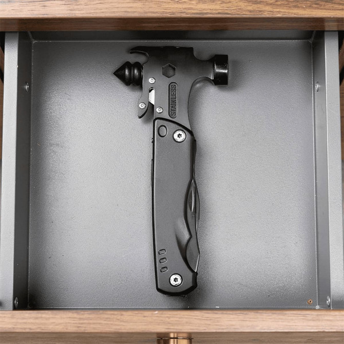 A black survival hammer with multiple tools, displayed in a grey drawer. It features a sleek design and a branding logo.