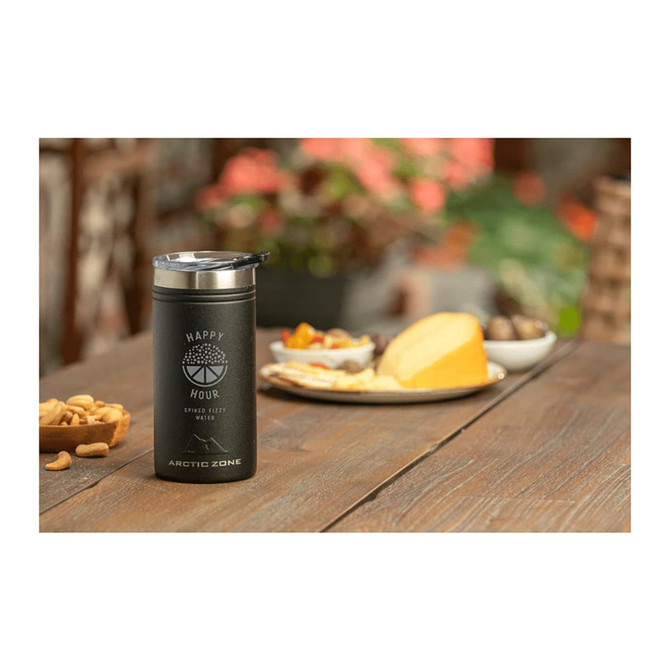 A drink bottle in black with a stainless steel top, placed on a table next to a platter of snacks.