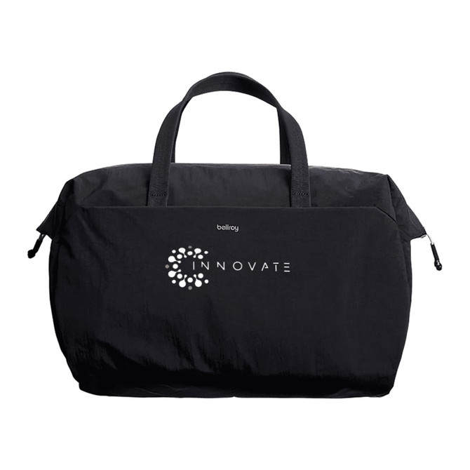A black duffel bag with short handles and a branding logo on the front.