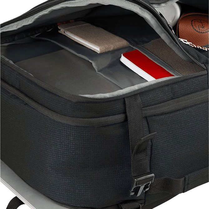 An open black travel backpack displaying multiple compartments containing notebooks and a small device.