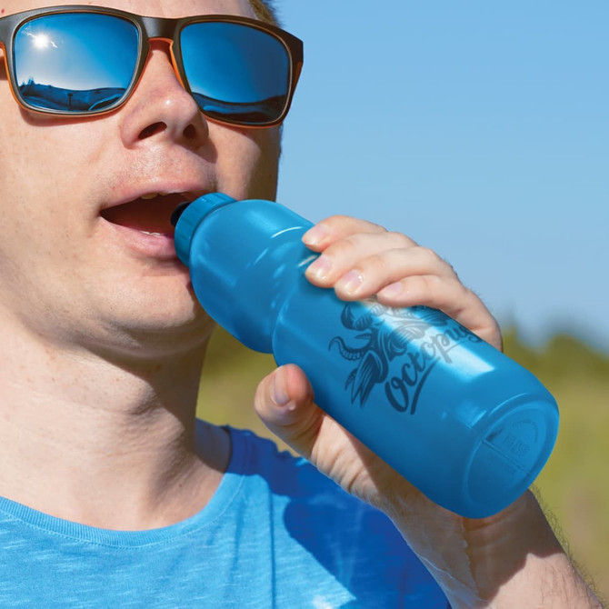 A drink bottle in a vibrant blue color, featuring a logo, is being held and used by a person wearing sunglasses.