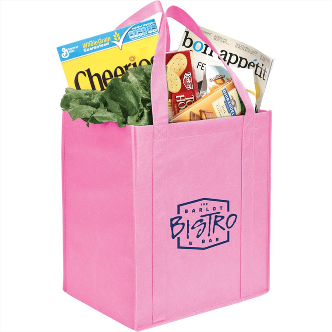 A pink non-woven grocery tote filled with lettuce, cereal, and snack boxes, featuring a logo on the front.