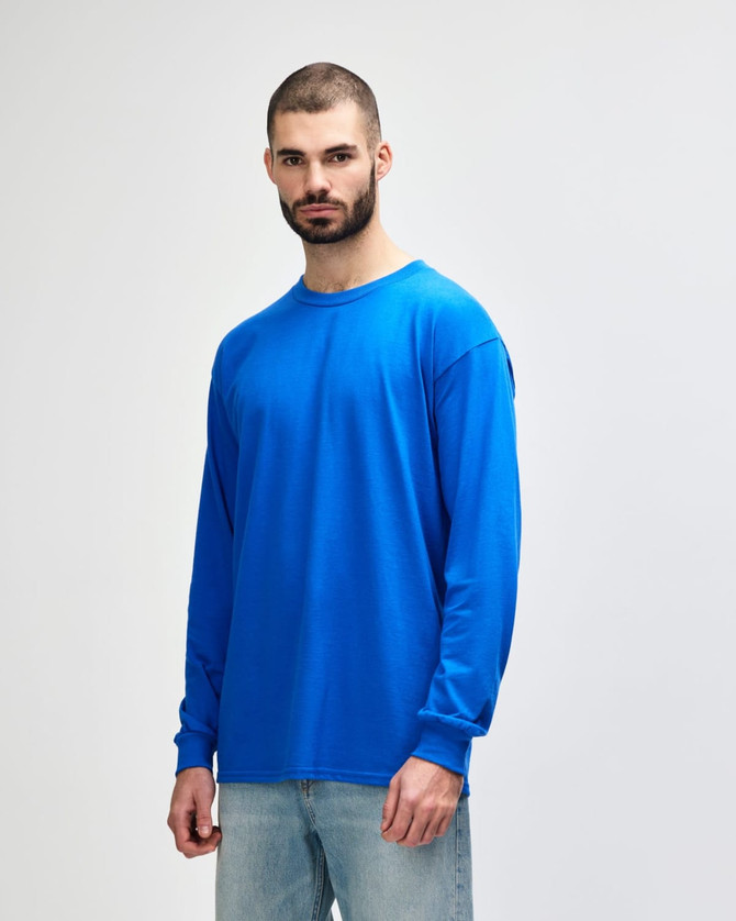 A long-sleeve T-shirt in bright blue, featuring a logo, worn by a model facing left.