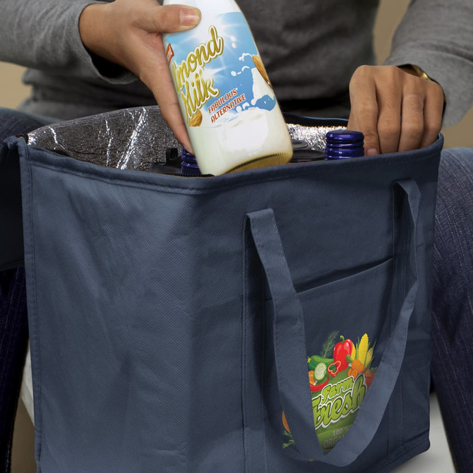 A drink bottle is being placed into a navy cooler bag with an interior lining, featuring a logo.