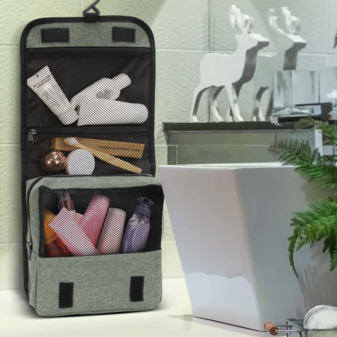 A grey toiletry bag with mesh pockets filled with various toiletry items like bottles and tubes. Features a hanging design.