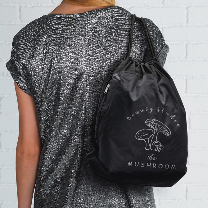 A black drawstring backpack with a logo, carried on a person's shoulder.