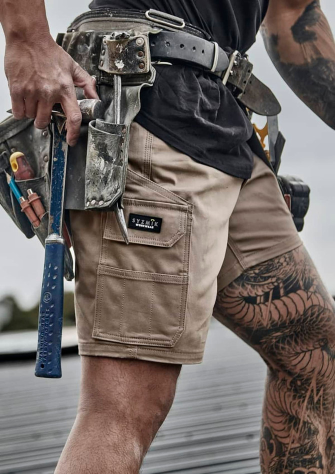 Men's essential stretch cargo shorts in light brown, featuring multiple pockets and a branding label.