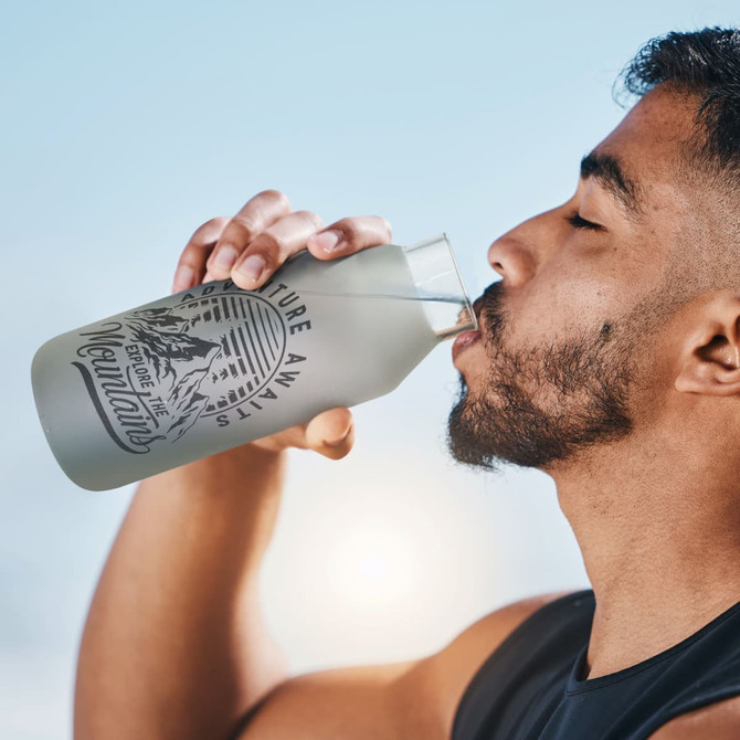 A drink bottle in a frosted finish, featuring a logo, held by a man drinking.