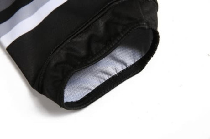 A black and white ice hockey racing suit sleeve featuring an elastic cuff, with a soft inner lining.