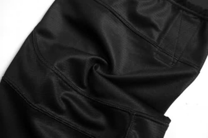 A black ice hockey racing suit featuring textured fabric and stitching details, ideal for sports uniforms.