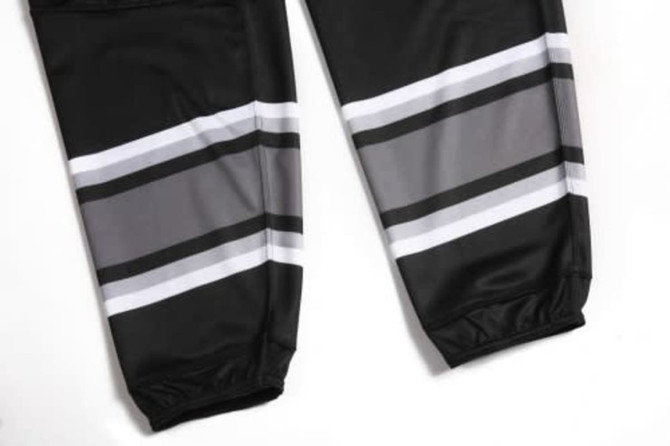 A pair of black racing pants with grey and white stripes, featuring a fitted design and elastic cuffs.