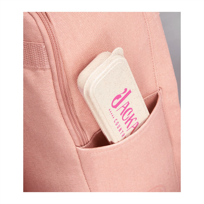 A pink backpack with a cream-coloured bamboo fibre cutlery set case peeking out from a side pocket.