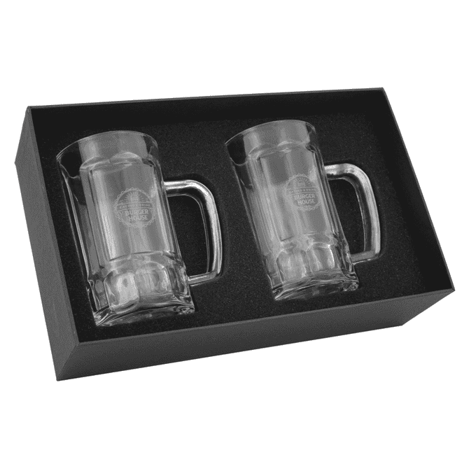 A set of two clear glass Bavarian beer mugs, packaged in a black gift box, featuring a logo.
