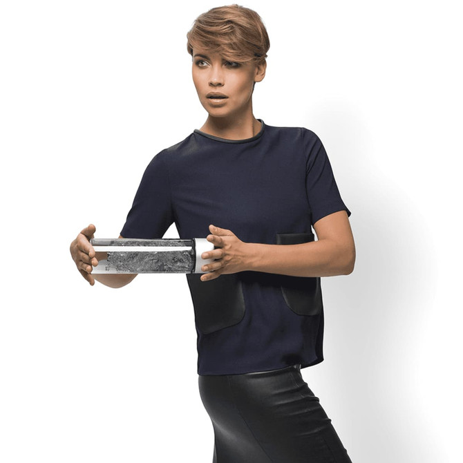 A drink bottle with a sleek silver design, featuring a logo, held by a person in a stylish outfit.