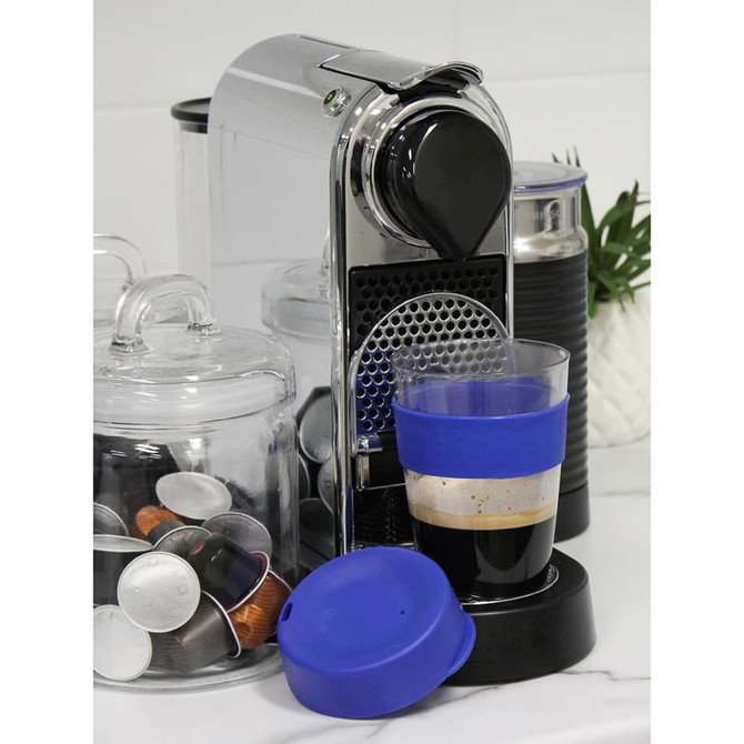 A drink bottle with a blue silicone band and lid, next to a coffee machine and coffee capsule containers.