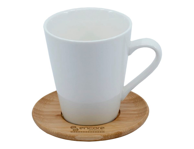 A white ceramic mug with a handle, sitting on a round bamboo saucer. The mug has a smooth, glossy finish.